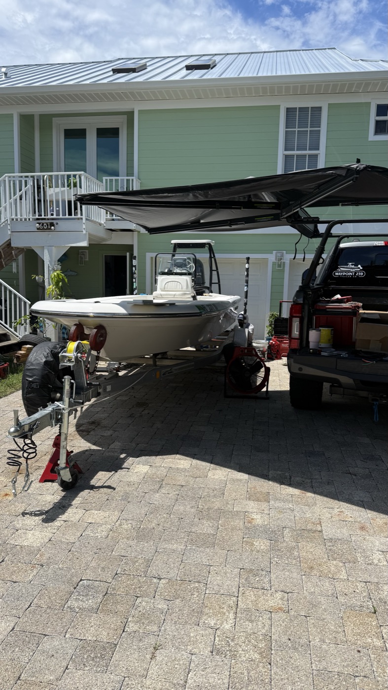 Waypoint 239 mobile rig set up on-site next to a flats boat on its trailer