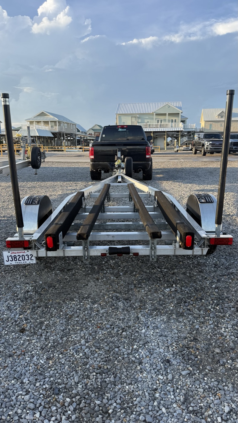 Aluminum bunk trailer ready to go, with a pickup truck hitched in front