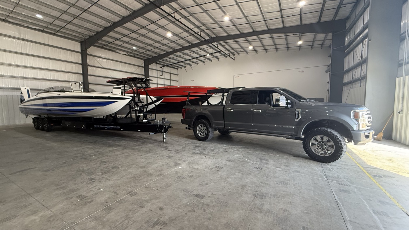 Waypoint 239 truck in a boat storage warehouse beside boats on trailers